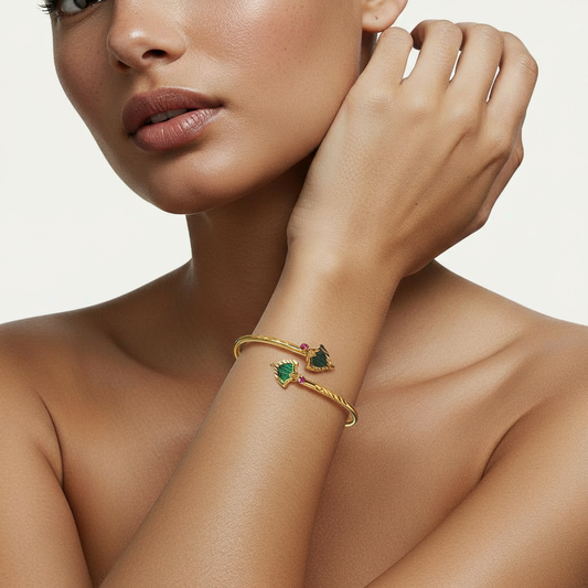 A woman wearing a Me19 micro gold-plated Palakka twisted cuff bangle with green and red stones. A traditional yet modern piece of artificial jewellery from Kerala, India.