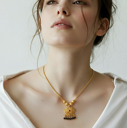 A woman wearing a Me19 micro gold-plated lotus pendant necklace with black bead drops. A traditional and elegant piece of artificial temple jewellery from Thrissur, Kerala.