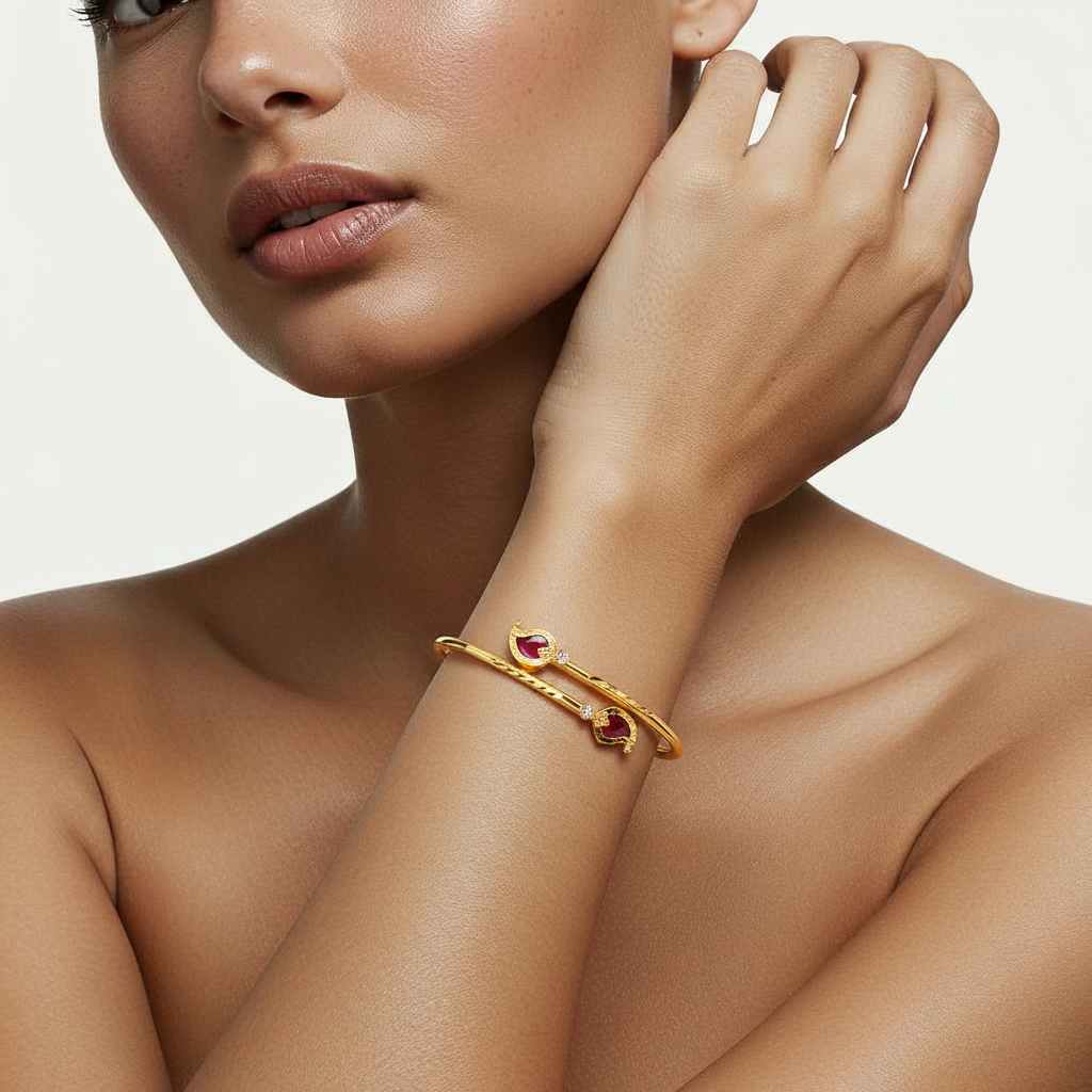 A woman wearing a Me19 micro gold-plated mango cuff bangle with red stones. A traditional yet modern piece of artificial jewellery from Kerala, India